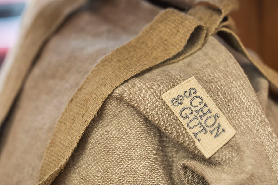 Nahaufnahme einer naturfarbenen, handgenähten Tasche mit sichtbarem SCHÖN&GUT-Logo.